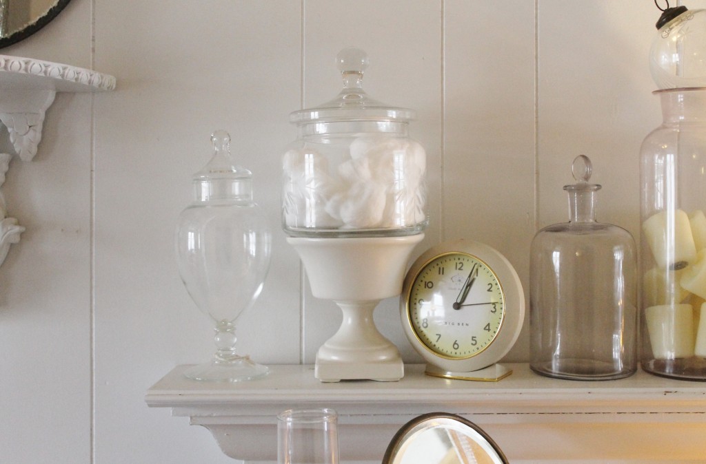 A variety of vintage jars collected from all over next to a vintage reproduction clock.