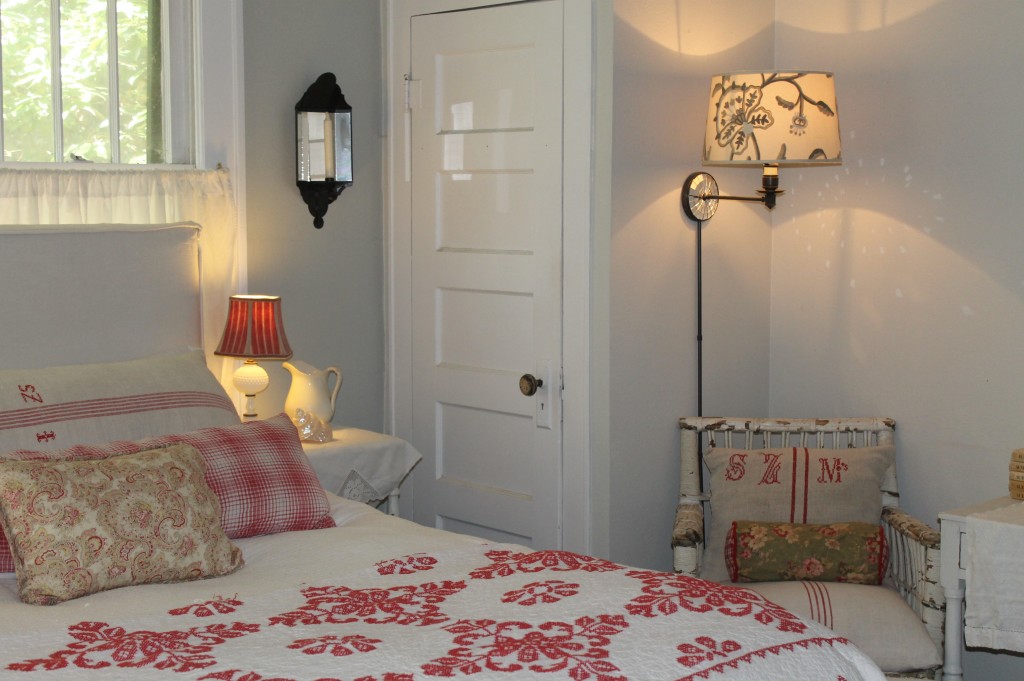 An old quilt, pillows made from vintage fabric and a ambient lighting make this one cozy bedroom.