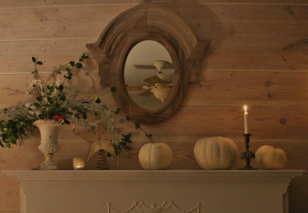 The white pumpkins signal fall and winter along with a distressed star shaped mirror and winter arrangment