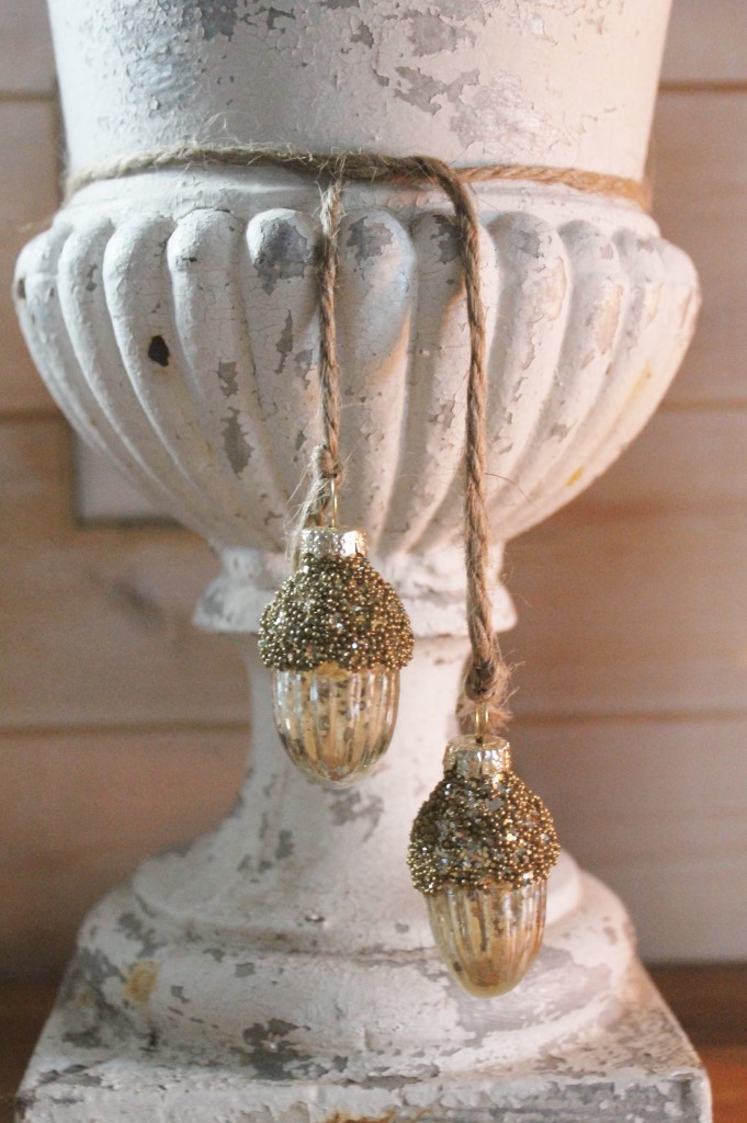 Against the worn surface of the urn, small acorn mercury glass ornaments from Targets ($4 for three).  Simple rustic twine will do for hanging.