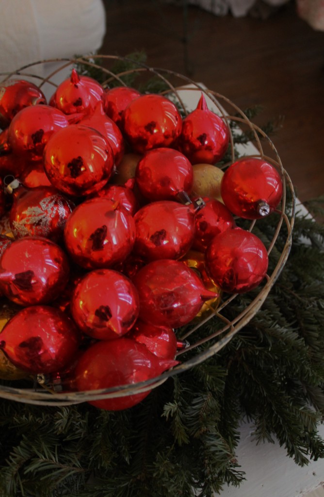 Vintage, hand blown ornaments in a wire basket, setting softly on  a wreath on my coffee table.