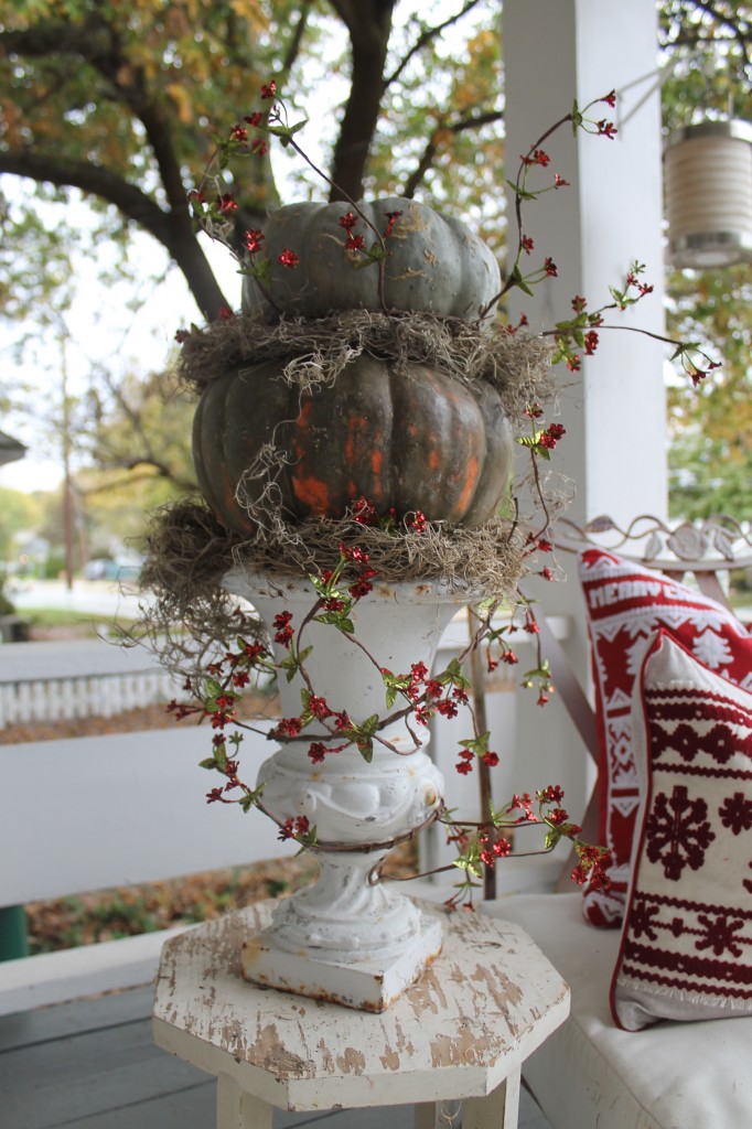 Fall pumpkins, stacked and tucked with moss, followed by a Christmas garland presented in an old cast iron urn. It's one way to transition from fall to Christmas, using what you already have.