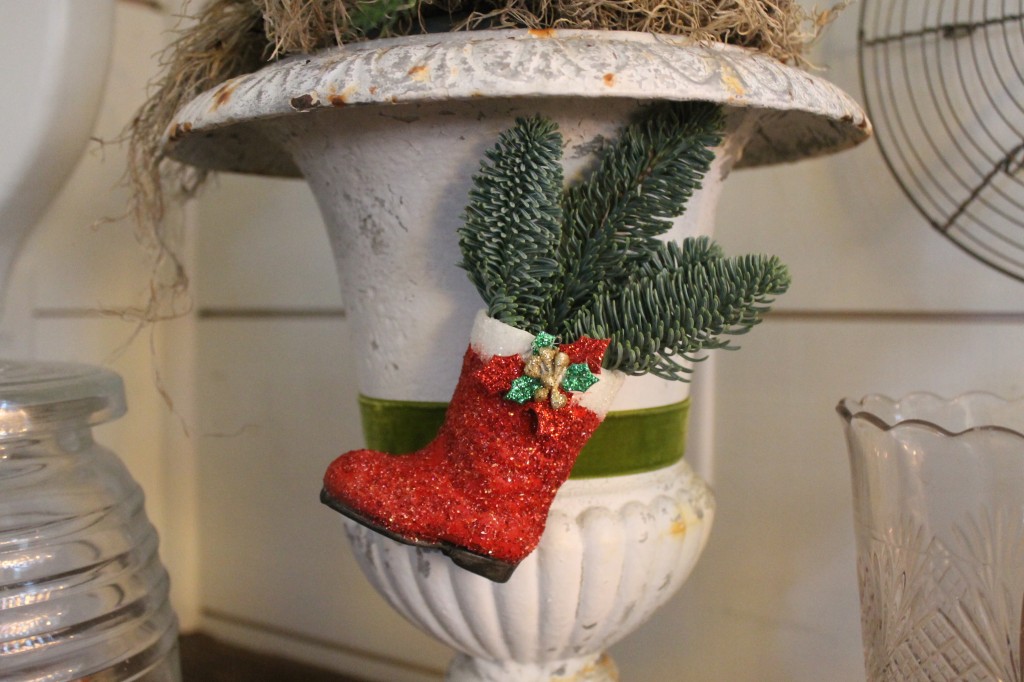 A papier mache Santa boot that I painted then adorned with German Glitter Glass and a holiday embellishment, topped off with a fresh sprig of greens.