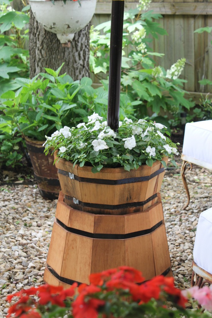 Two cedar planters, one smaller and one larger were used. Purchased from Lowe's, a hole was drilled in both of them to allow them to slide down the center pole. The larger was turned upside down, the smaller was filled with some plastic at the bottom, potting soil and flowers. A simple pressure fit (with the help of a rubber mallet) was all that was needed to create one unit.