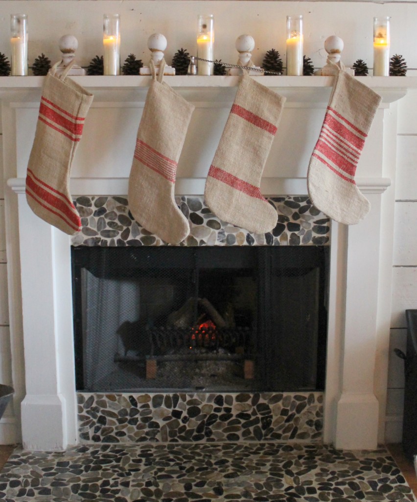 Using old, white chippy cast iron finials to hang grain sack stockings.